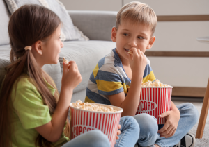 dzieci jedzą popcorn