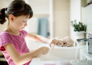 dziecko nakłada pastę na szczoteczkę