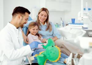 dentysta pokazuje dziecku jak szczotkować zęby